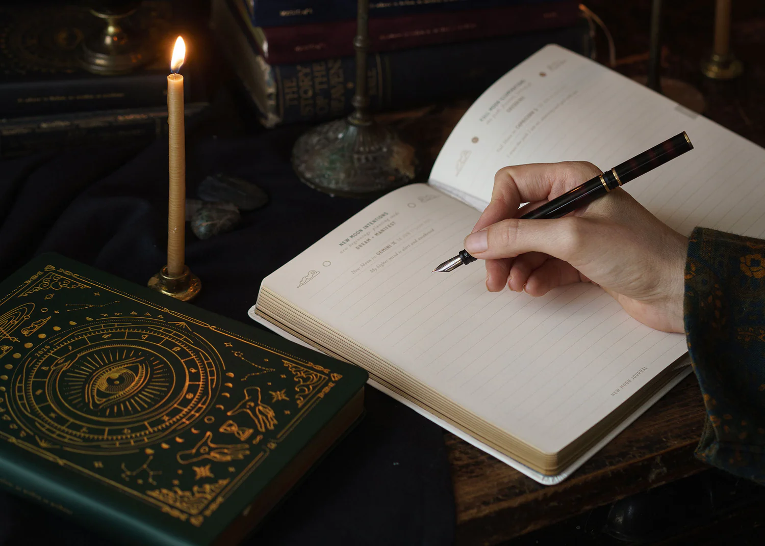 Planner-on-table-pen-in-hand_3_1500x NAUJA! 2026 metų astrologinė planuotė (samanų spalva) - Image 4